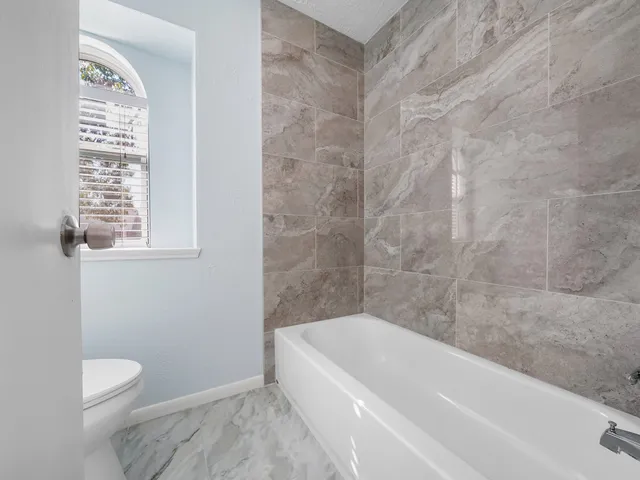 a bathroom with a bathtub and window