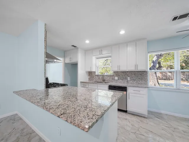 a kitchen with kitchen island granite countertop a sink and counter space