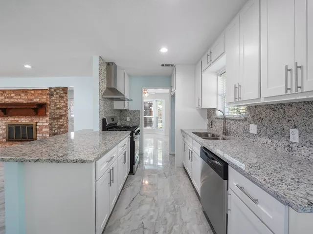 a kitchen with stainless steel appliances granite countertop a sink stove and cabinets
