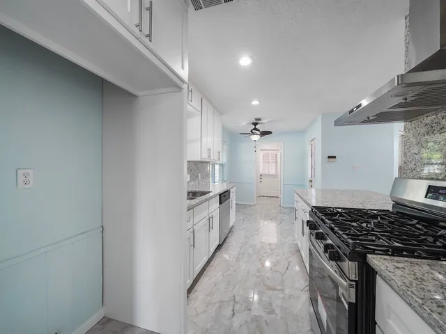 a kitchen with white cabinets and appliances