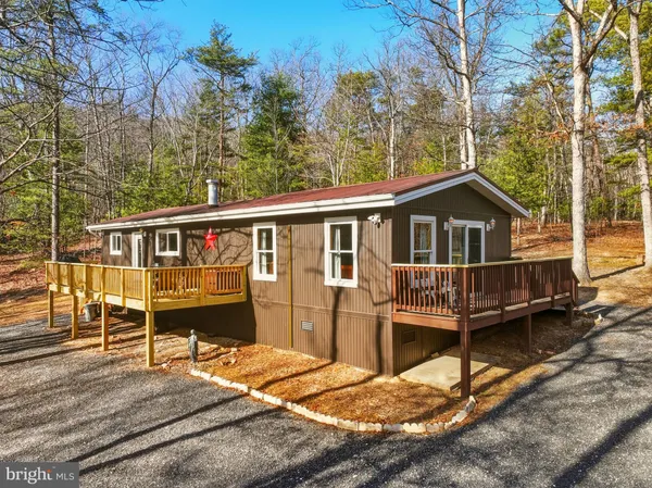 a view of a house with a wooden deck and a backyard