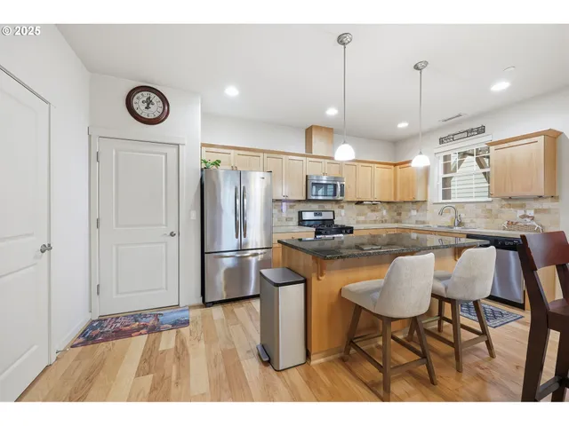 a kitchen with a table chairs refrigerator and microwave