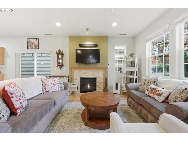 a living room with furniture a flat screen tv and a fireplace