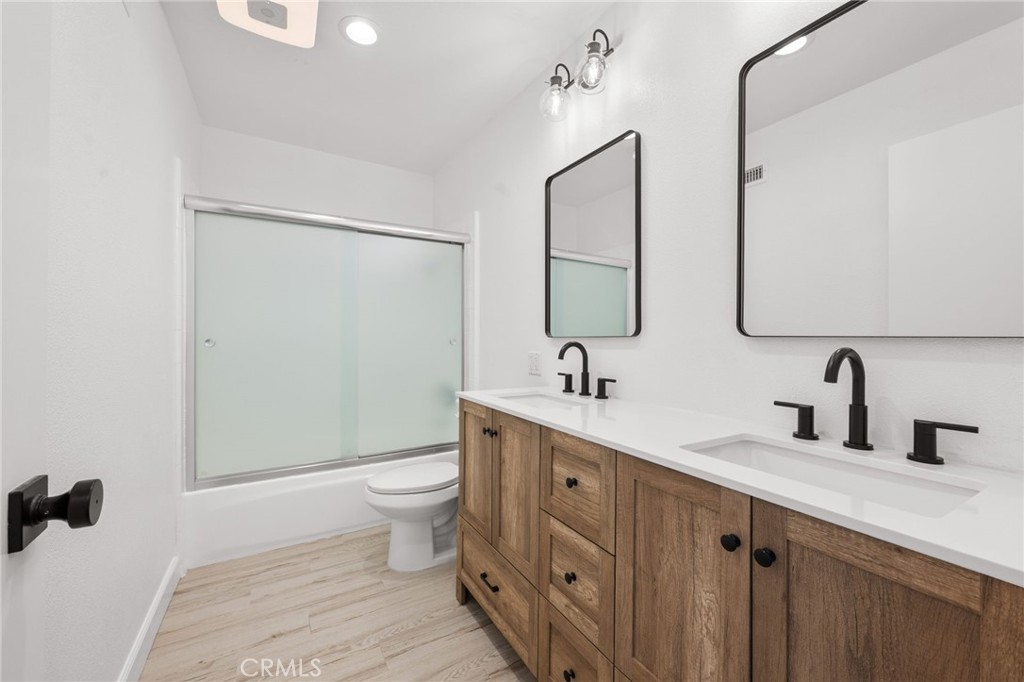10179 Larwin Avenue, Unit 5 Chatsworth, CA 91311 - Photo 16 of 53 a bathroom with a double vanity sink toilet and mirror