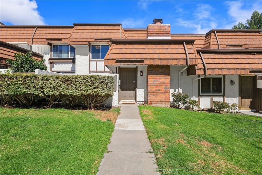 10179 Larwin Avenue, Unit 5 Chatsworth, CA 91311 - Photo 22 of 53 a front view of a house with a yard