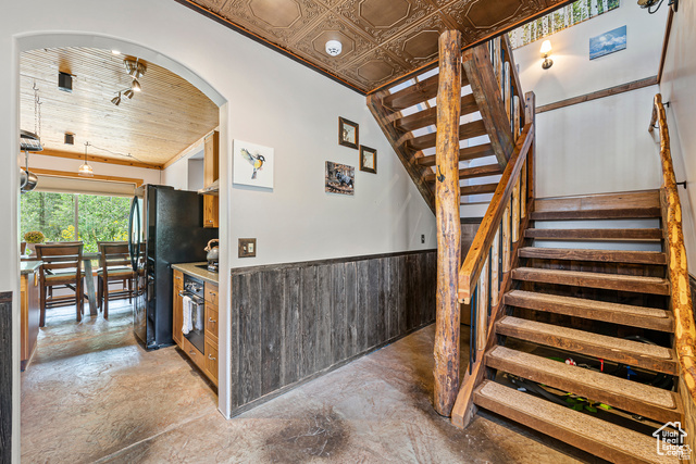 2029 West Tollgate Road Coalville, UT 84017 - Photo 5 of 43 Stairs with a wainscoted wall, wooden walls, finished concrete flooring, and an ornate ceiling