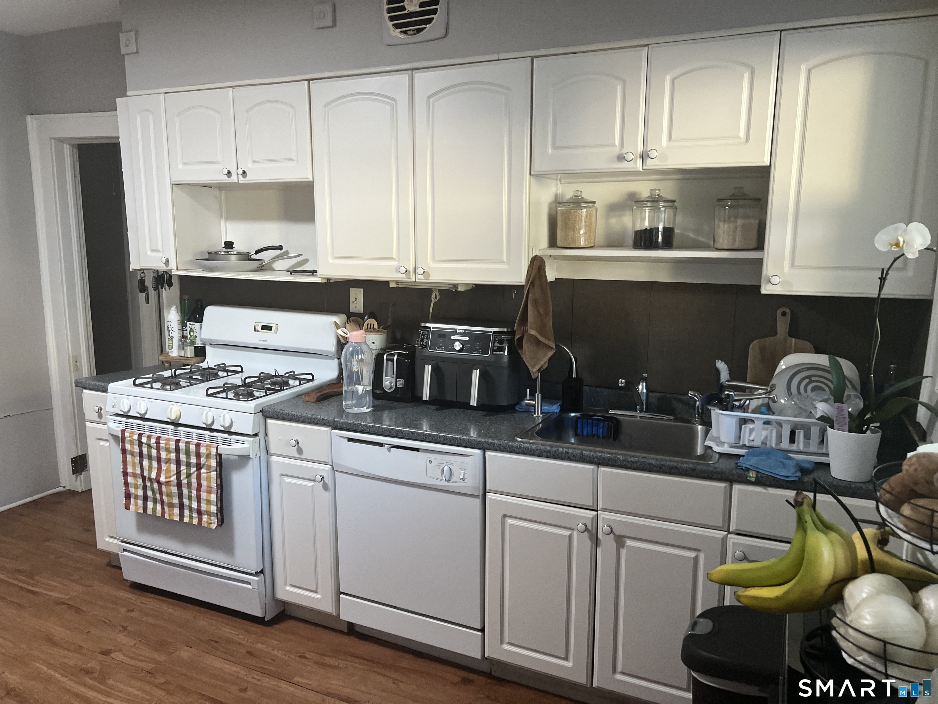 275 Long Ridge Road Stamford, CT 06905 - Photo 5 of 40 a kitchen with kitchen island granite countertop a sink cabinets and wooden floor