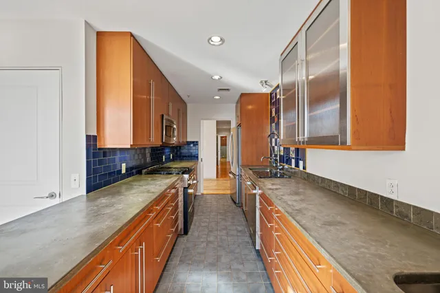 a kitchen with stainless steel appliances granite countertop a stove and a sink