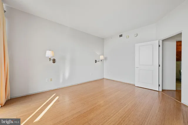 a view of an empty room with wooden floor