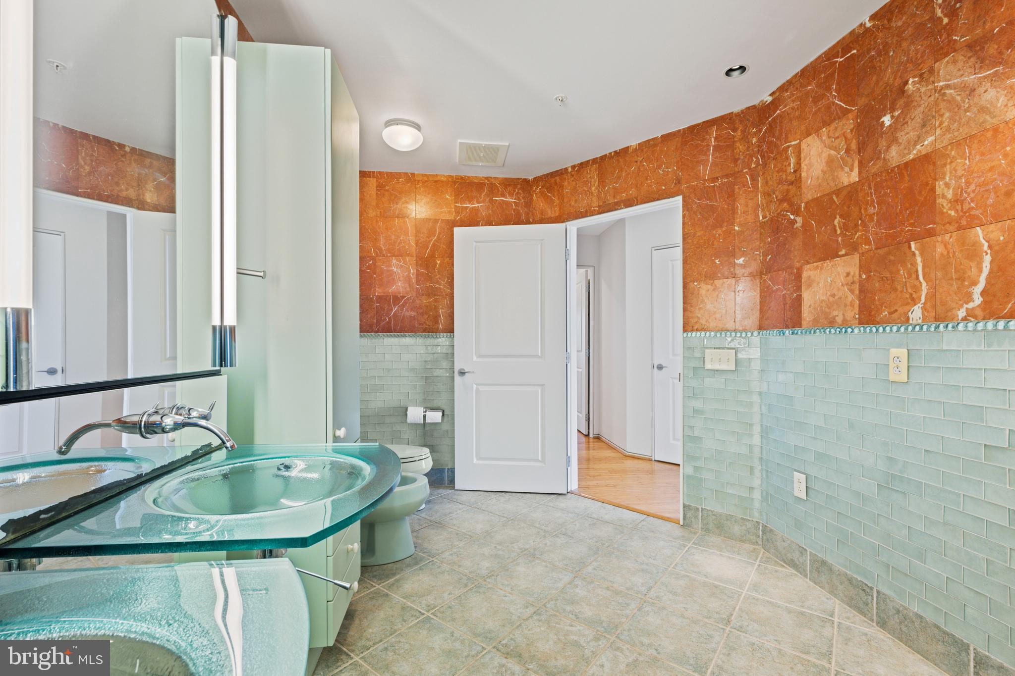 717 President Street, Unit 504 Baltimore, MD 21202 - Photo 25 of 29 a bathroom with a granite countertop sink and a mirror