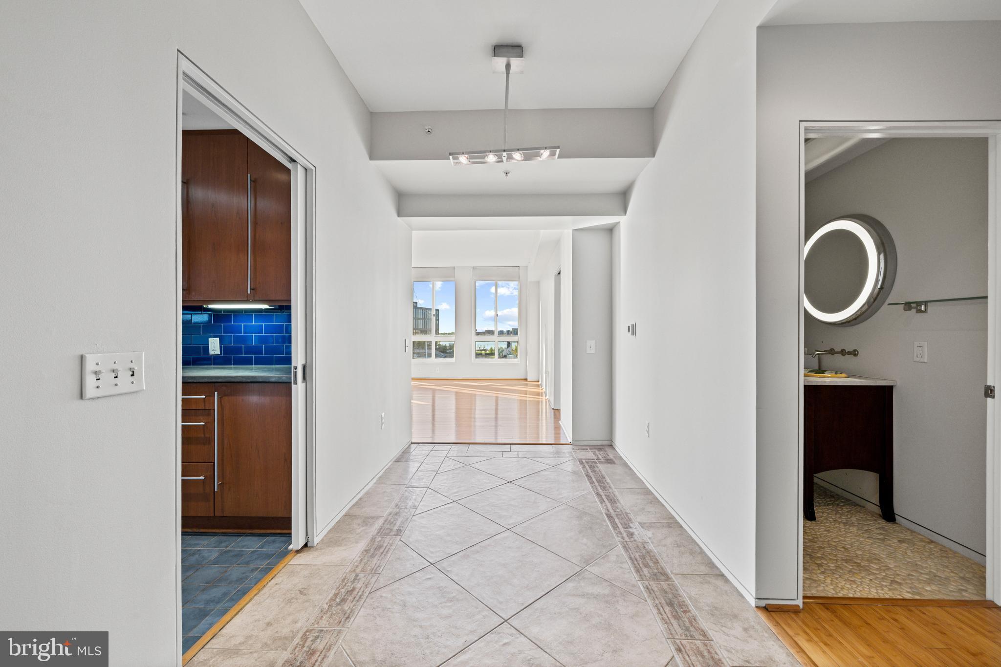 717 President Street, Unit 504 Baltimore, MD 21202 - Photo 4 of 29 a view of a hallway with wooden floor and a chandelier