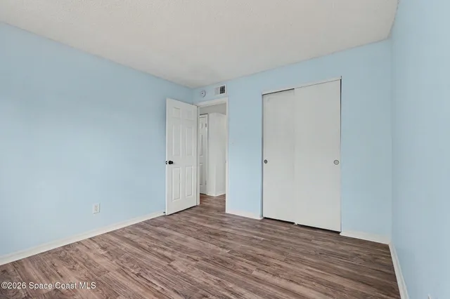 a view of empty room with wooden floor