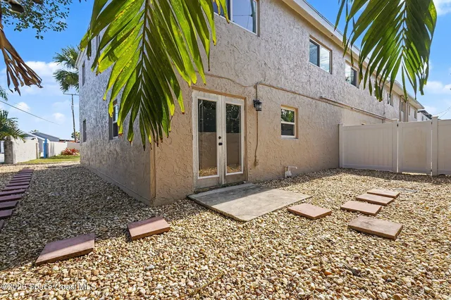 a couple of palm trees in front of house