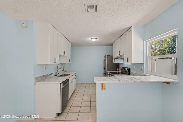 a kitchen with a sink a stove and cabinets