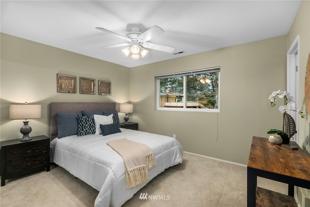 707 Harvest Road Bothell, WA 98012 - Photo 11 of 27 a bedroom with a bed and a chandelier