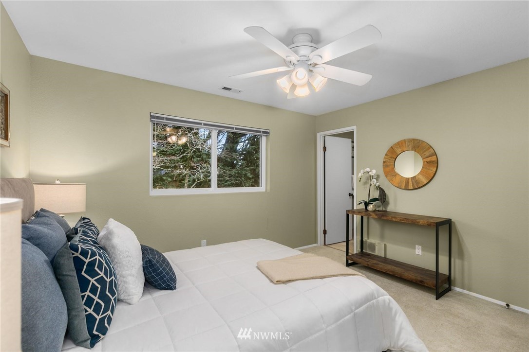 707 Harvest Road Bothell, WA 98012 - Photo 12 of 27 a bedroom with a bed and a chandelier
