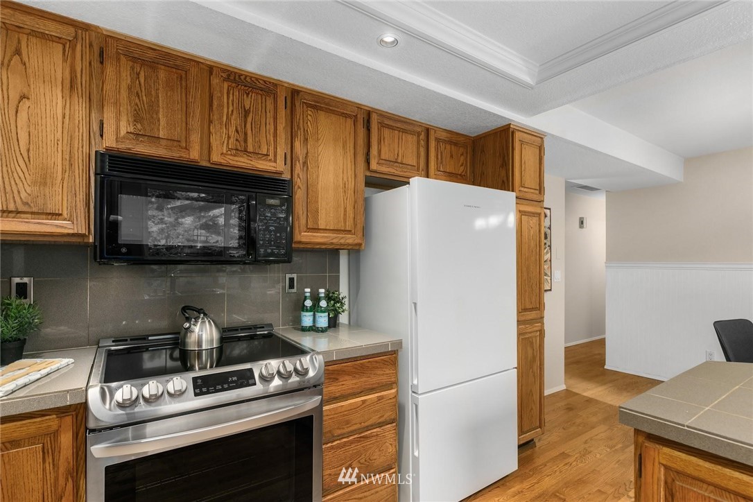 707 Harvest Road Bothell, WA 98012 - Photo 9 of 27 a kitchen with stainless steel appliances granite countertop a refrigerator stove and microwave