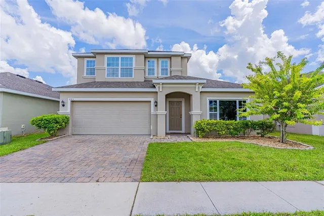 a front view of a house with a yard and garage