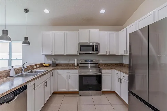 a kitchen with white cabinets stainless steel appliances and a sink
