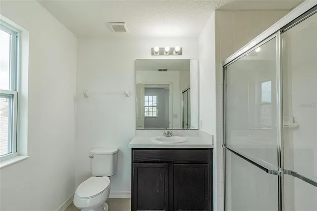 a bathroom with a sink a toilet and shower curtain