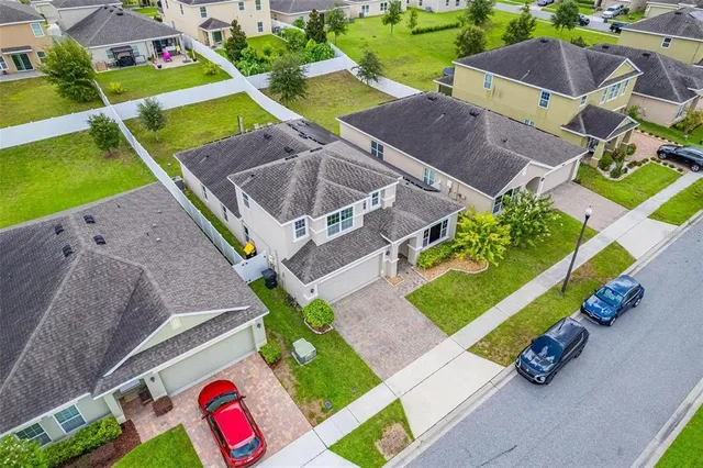 a front view of a house with a yard and potted plants