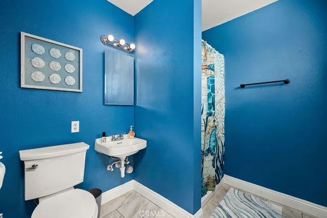 a bathroom with a toilet a sink and mirror