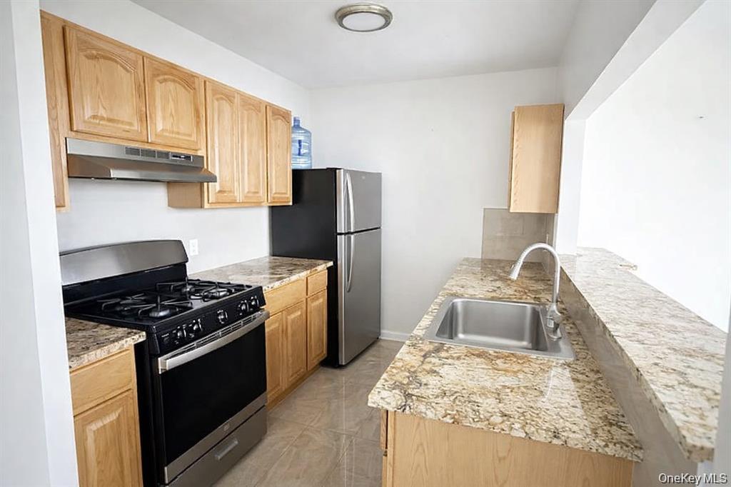 a kitchen with granite countertop a stove and a refrigerator