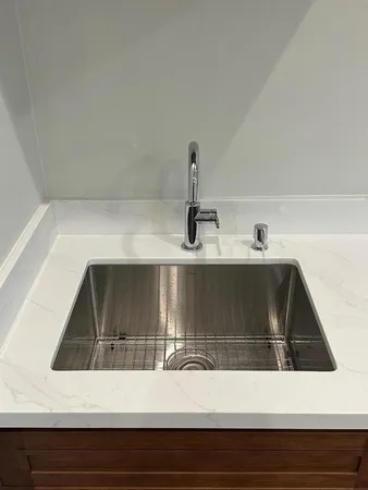 a kitchen with a sink and a mirror