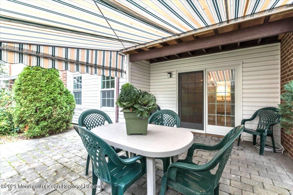 121 Walnut Drive Spring Lake Heights, NJ 07762 - Photo 31 of 44 a view of a patio with a table and chairs and potted plants