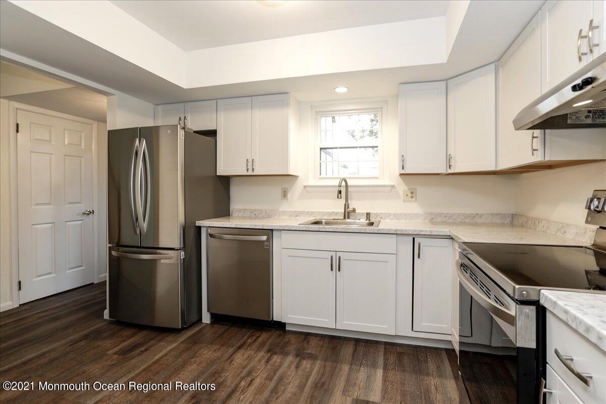 121 Walnut Drive Spring Lake Heights, NJ 07762 - Photo 7 of 44 a kitchen with a refrigerator stove and wooden cabinets
