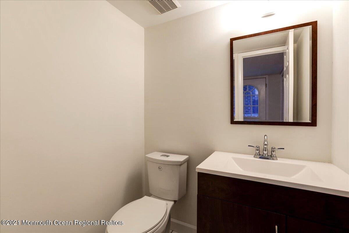 121 Walnut Drive Spring Lake Heights, NJ 07762 - Photo 10 of 44 a bathroom with a toilet a sink and mirror