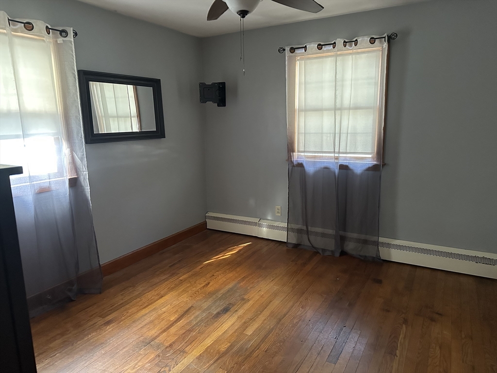 310 Palmer Road Ware, MA 01082 - Photo 11 of 16 an empty room with wooden floor and windows