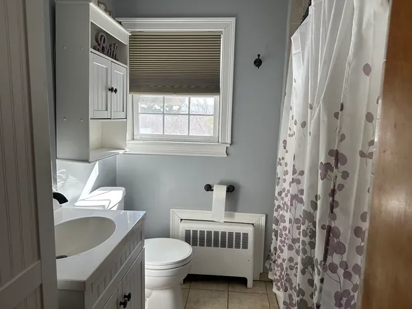 a bathroom with a toilet a sink and a mirror