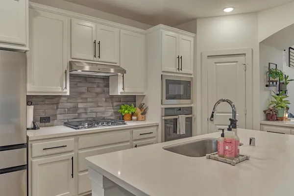 a kitchen with stainless steel appliances granite countertop a sink stove and cabinets