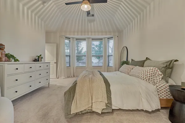 a bedroom with a bed a dresser and next to a window