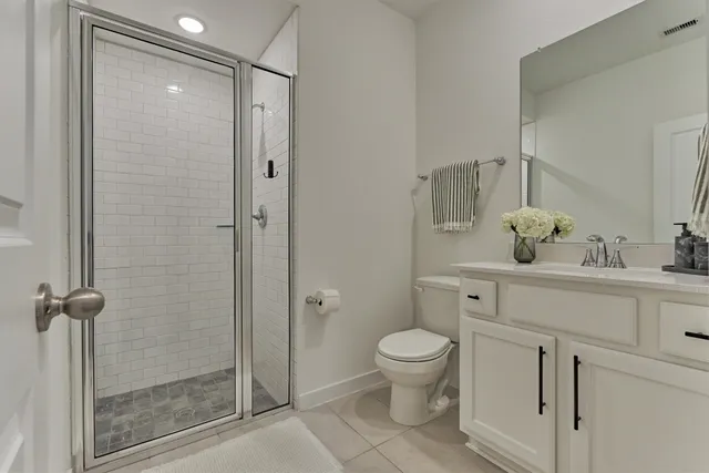 a bathroom with a shower sink vanity and toilet