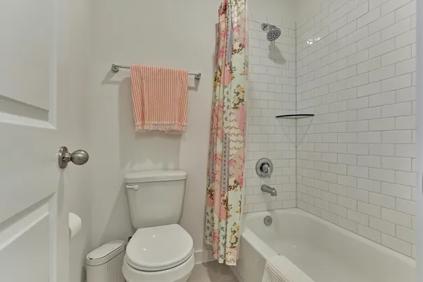 a white toilet sitting next to a bath tub and shower