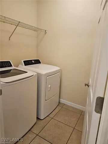 a view of backyard with large trees and wooden fence