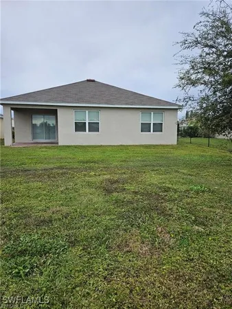 a view of a house with a yard and sitting area