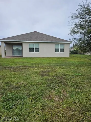 a view of a house with a yard and sitting area