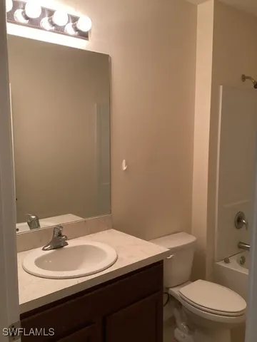 a bathroom with a granite countertop toilet a sink and shower