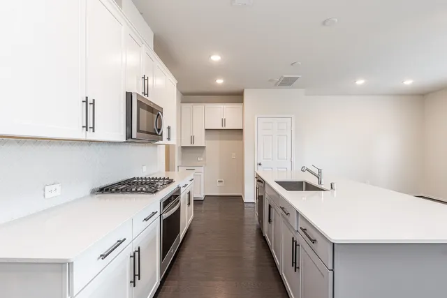 a kitchen with stainless steel appliances a sink stove top oven and cabinets