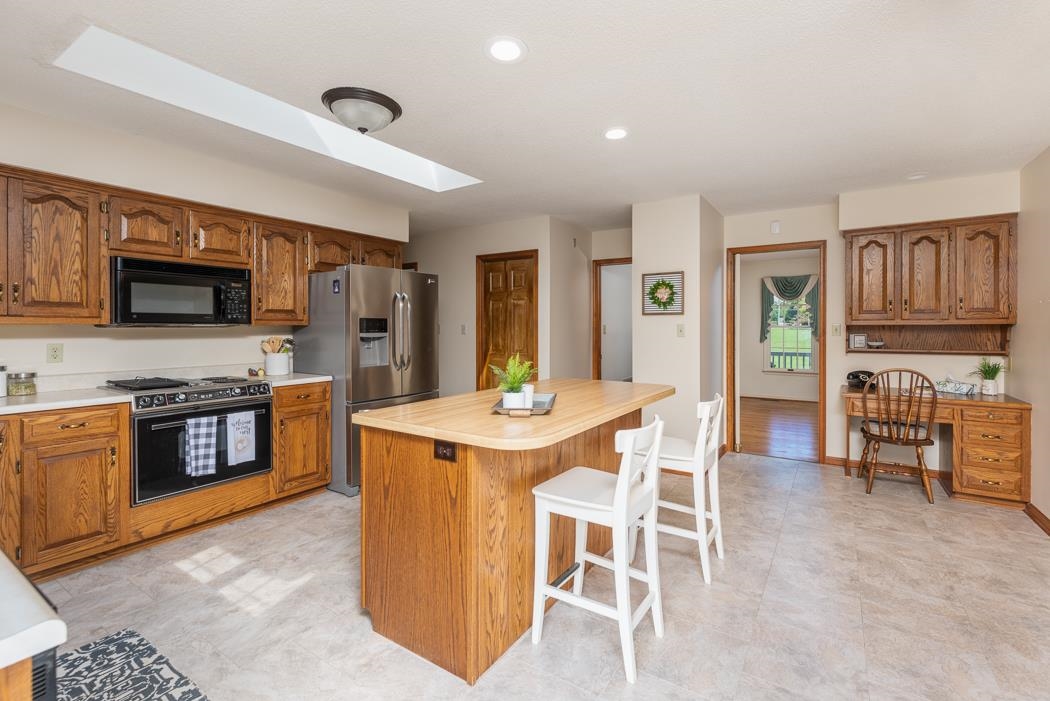1275 Ladd Road Waynesboro, VA 22980 - Photo 47 of 75 a kitchen with stainless steel appliances granite countertop a stove top oven a sink dishwasher a dining table and chairs with wooden floor