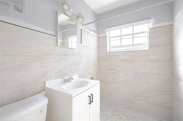 a bathroom with a sink a toilet and a mirror