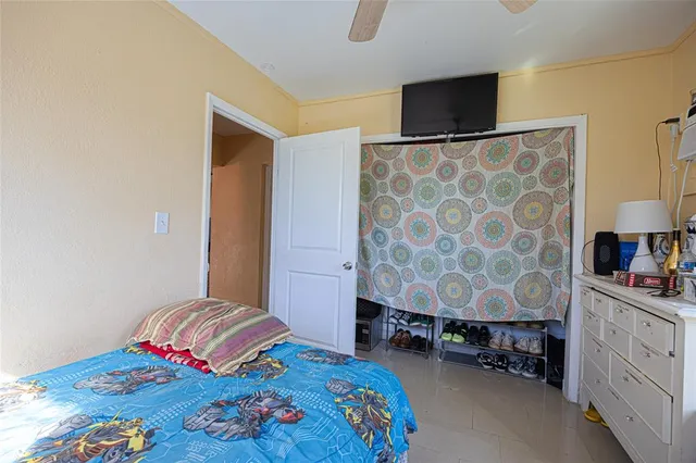 a bedroom with a bed and a lamp on the dresser