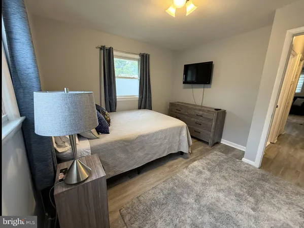 a bedroom with a bed tv and a window