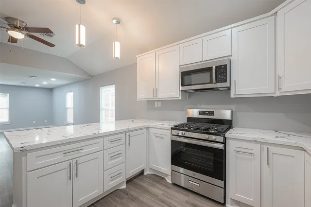 a kitchen with white cabinets and appliances