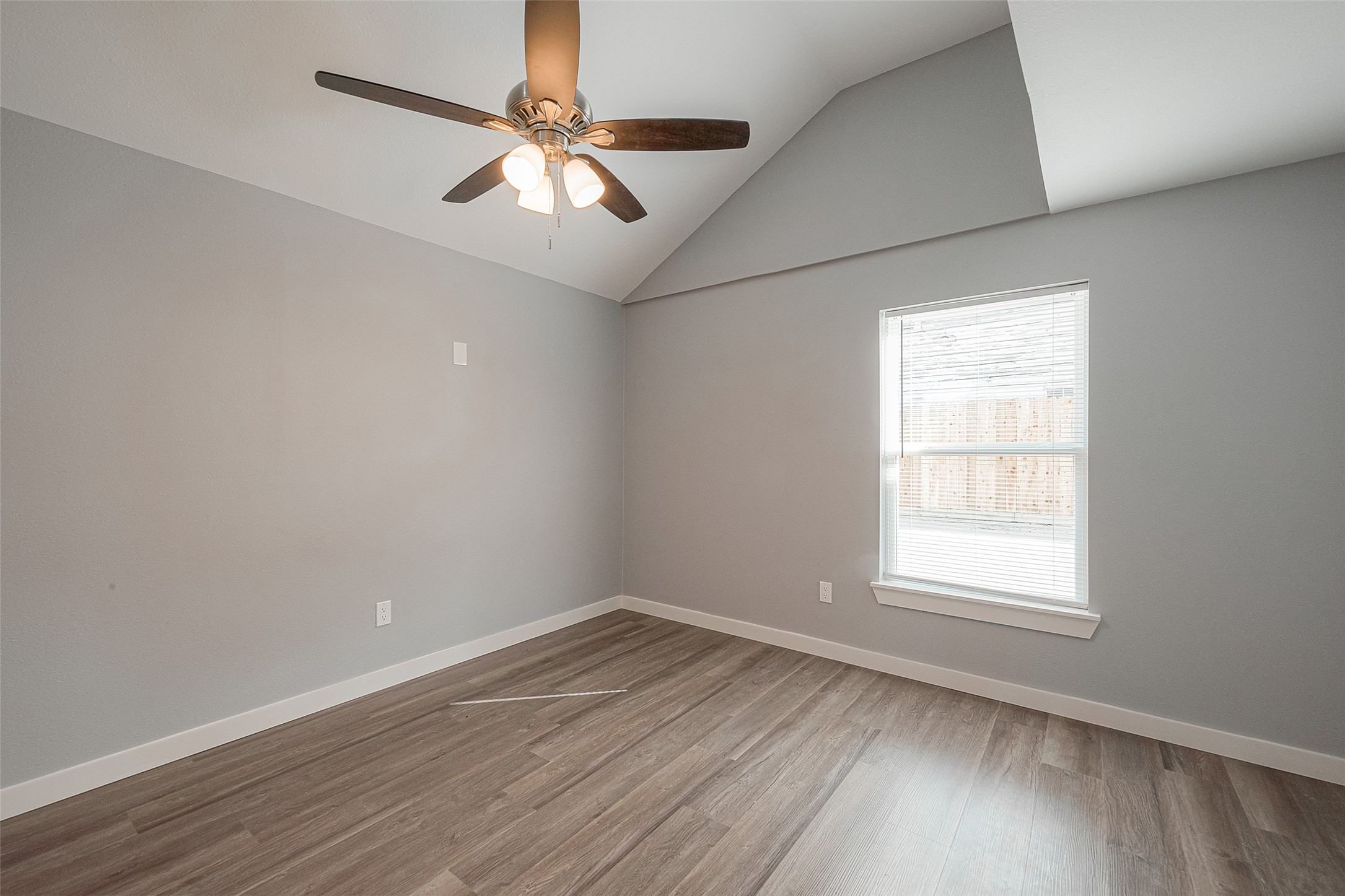 2725 Avenue F, Unit RR Rosenberg, TX 77471 - Photo 20 of 23 an empty room with wooden floor fan and windows