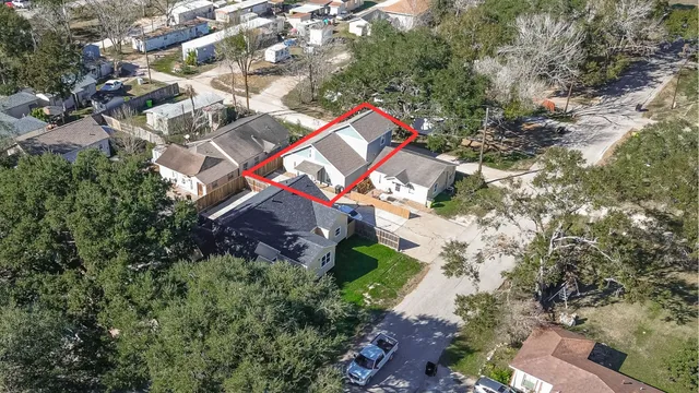 an aerial view of a house with a yard and a large tree