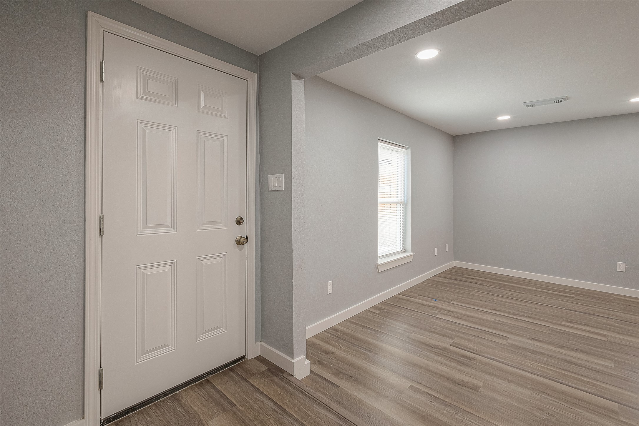 2725 Avenue F, Unit RR Rosenberg, TX 77471 - Photo 5 of 23 a view of an empty room with wooden floor and a window